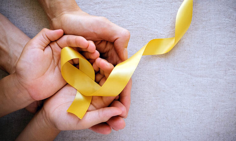adult and child hands holding yellow gold ribbon, Sarcoma Awaren